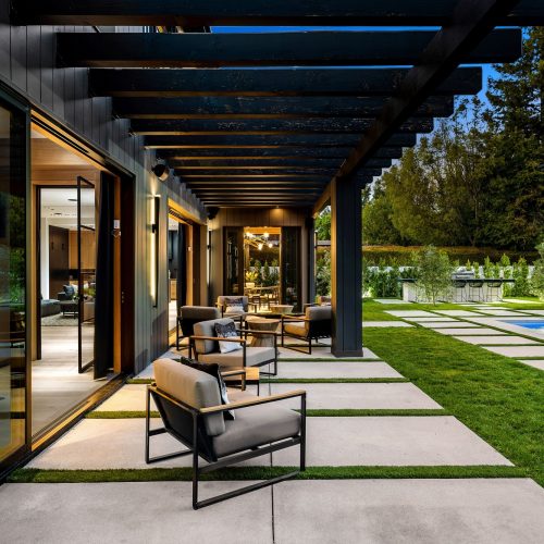 Modern outdoor patio with pergola and seating area.